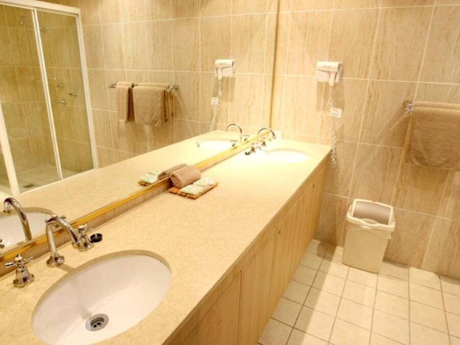 Un baño con un lavabo grande, un espejo y zona de ducha.