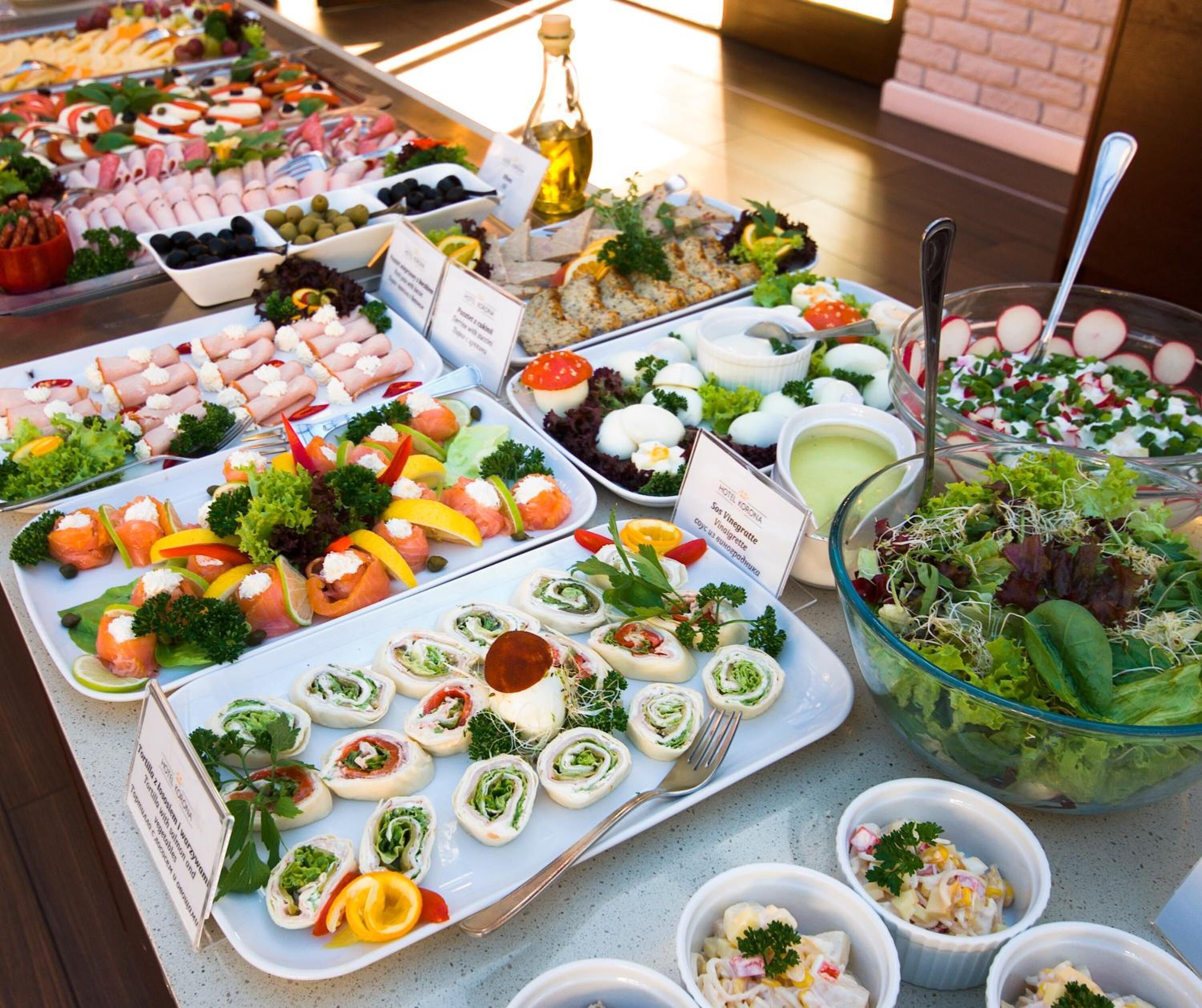 Een buffettafel met diverse gerechten, waaronder salades, vleeswaren en hapjes.