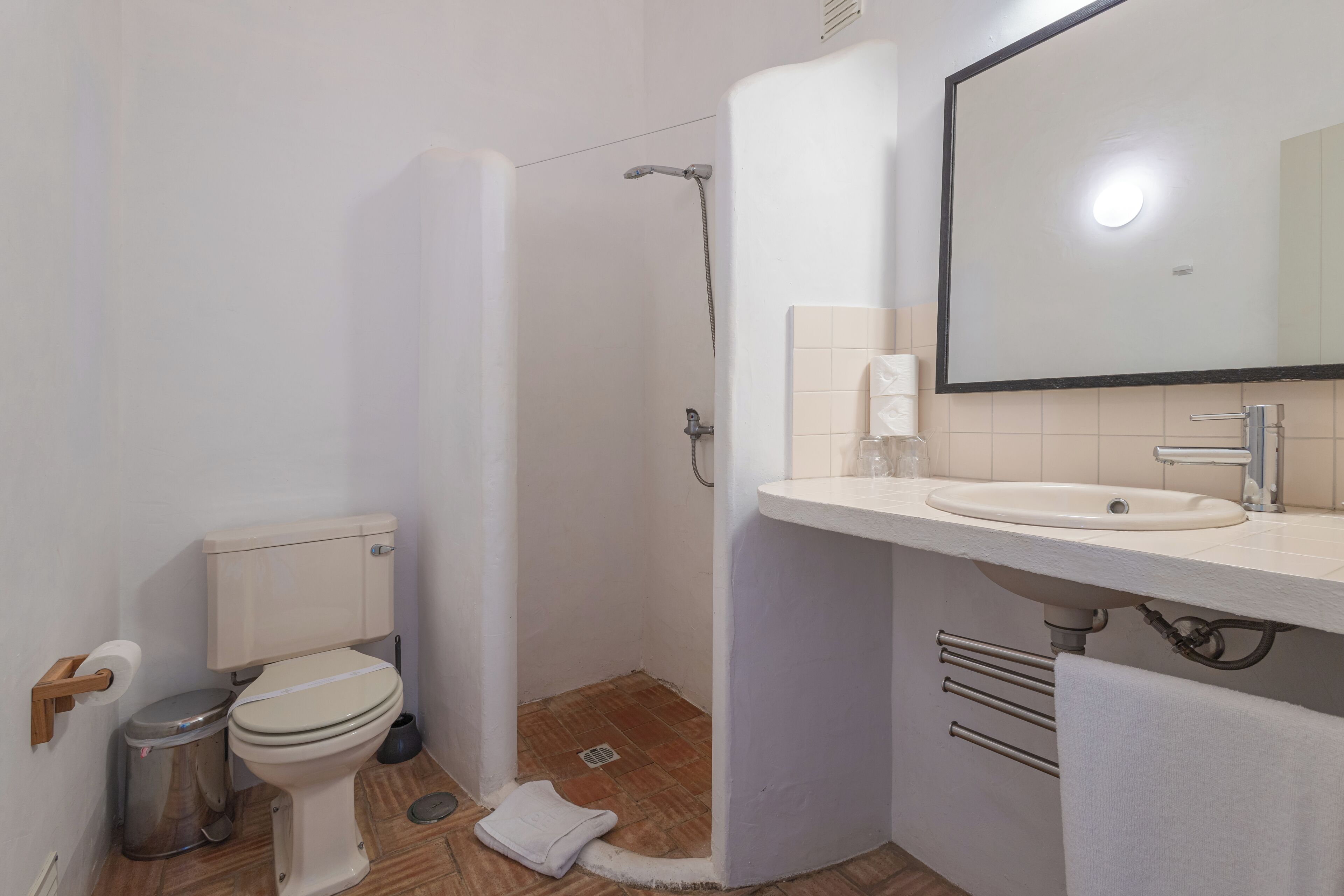 Un baño pequeño con inodoro, lavabo y ducha.