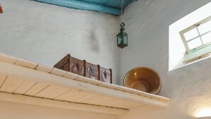 Une chambre avec deux lits, chacun recouvert d’une couverture rouge et blanche, et une petite table avec une lampe.