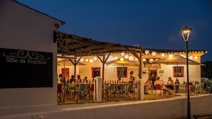 Un café con terraza, un letrero que dice "Sítio da Pedra" y un farol.