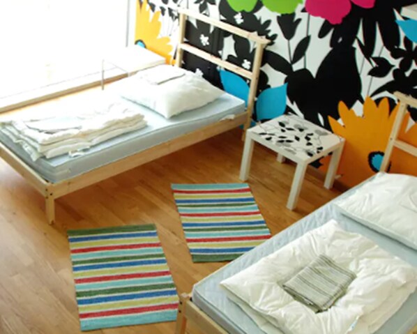 A room with a bed, a small table, and a chair. There are striped rugs on the floor. - Heart of Gold Hostel Berlin (Berlin)