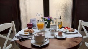 A breakfast table with croissants, a glass of orange juice, a cup of coffee, and a plate with eggs and tomatoes. - Hotel Le Clarisse al Pantheon (Rome)