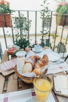 A breakfast table with bread, cheese, and a glass of juice.