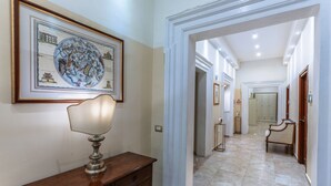 A hallway with a framed historical map, a classic lamp, and a wooden bench. - Hotel Le Clarisse al Pantheon (Rome)