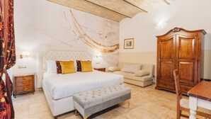 A bedroom with a bed, bedside tables, a bench, a wooden wardrobe, and a sofa. - Hotel Le Clarisse al Pantheon (Rome)
