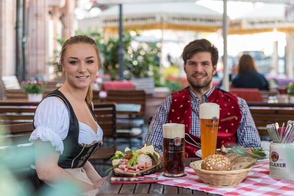 A dining table with a beer glass, a basket of bread, and a plate of food. - Pillhofer Hotel (Nuremberg)