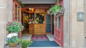 The entrance of a historic building with a wooden facade, a sign reading "Pillhofer 1646", and a welcome sign. - Pillhofer Hotel (Nuremberg)