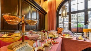 A buffet setup with various food items and a newspaper on a checkered tablecloth. - Pillhofer Hotel (Nuremberg)