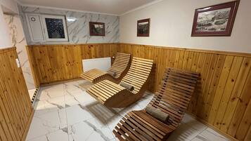 Una sauna con bancos de madera y suelo de losetas de mármol.