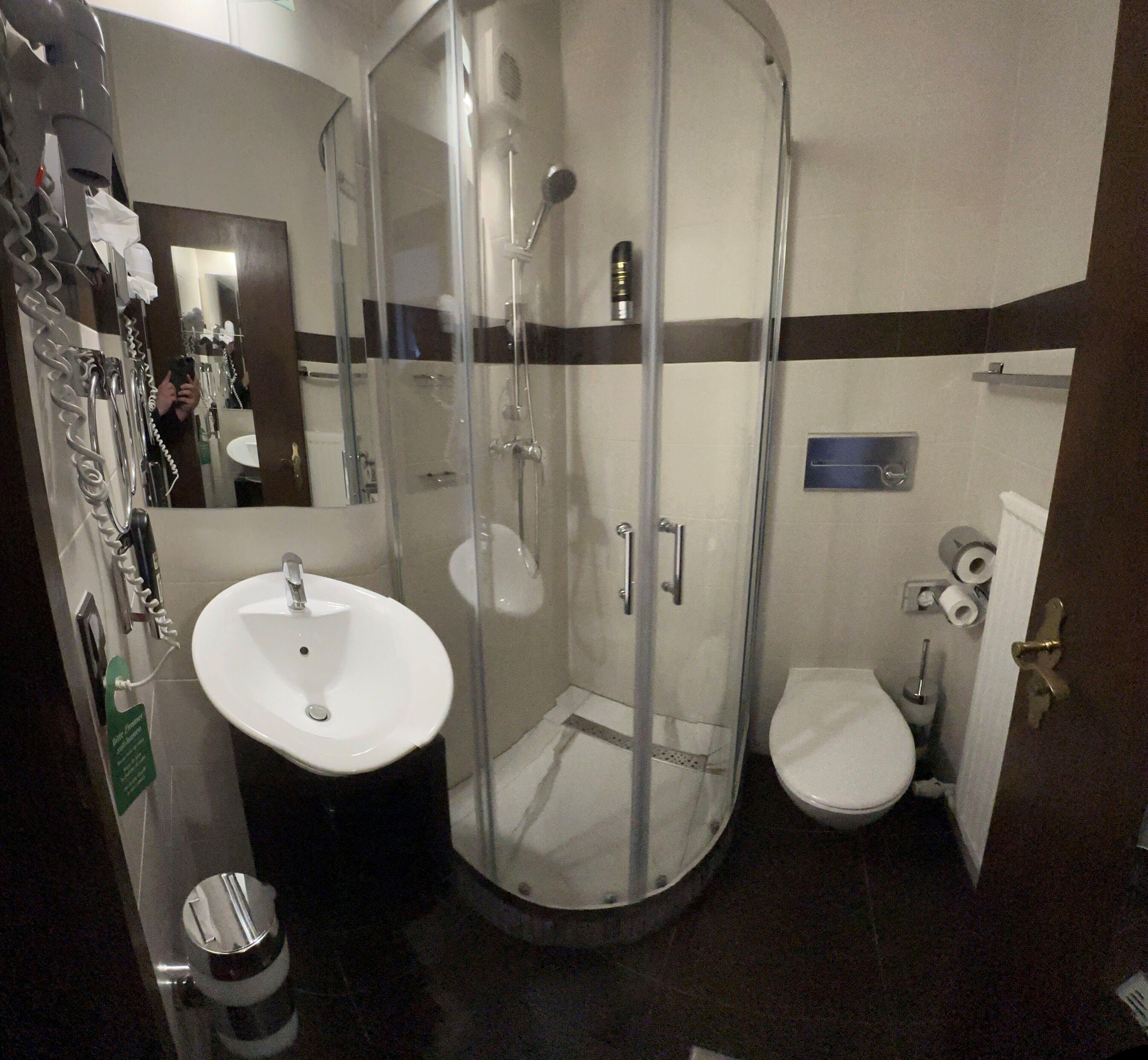 Une salle de bain compacte avec une douche à parois de verre, un lavabo et des toilettes.