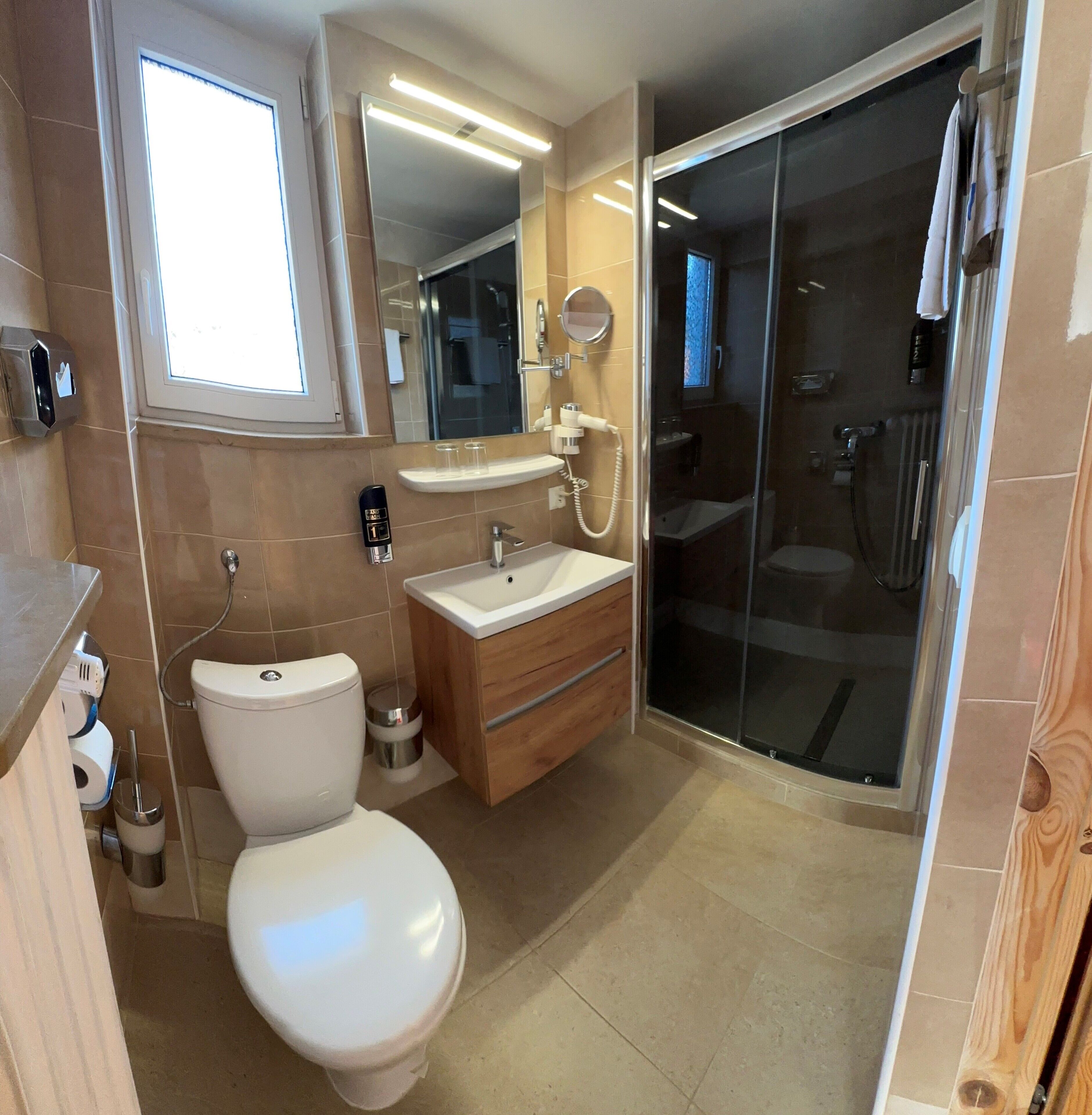 A modern bathroom with a toilet, sink, and shower area.