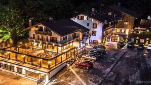 Un hotel de varios pisos con terraza y zona de estacionamiento.