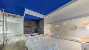 A modern hotel room with a starry ceiling, a large bed, a bathtub, and a minimalist bathroom. - Welikehotel Triton Beach (Capdepera)
