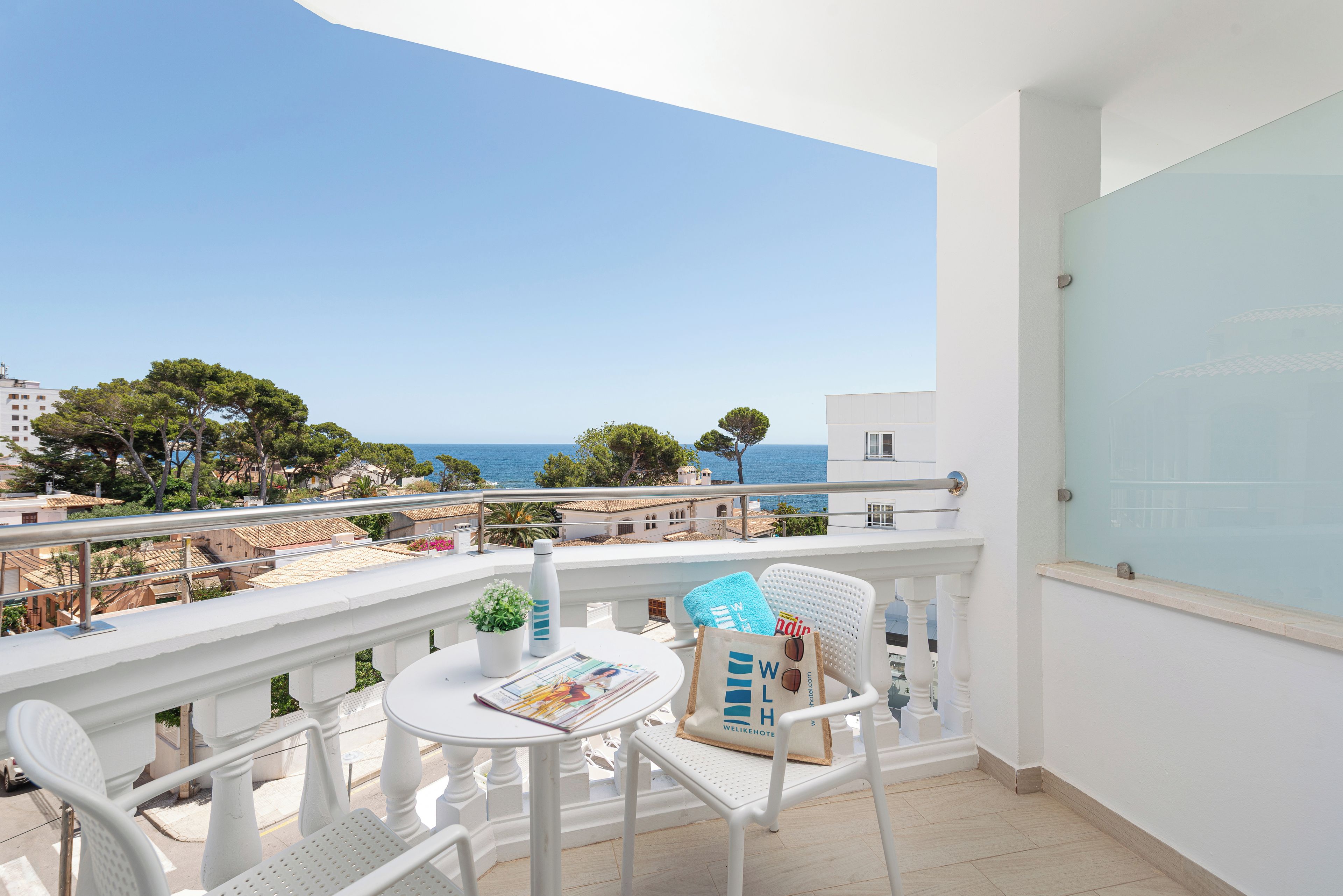 Un balcon avec une table, des chaises et une vue sur la mer.