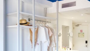 A modern hotel room with a white wardrobe, a mirror, and a bathroom with a sink and toilet. - Welikehotel Triton Beach (Capdepera)