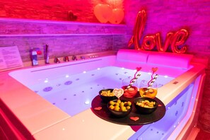 A spa area with a hot tub, heart-shaped decorations, and bowls of snacks. - Cleopatra (Rome)
