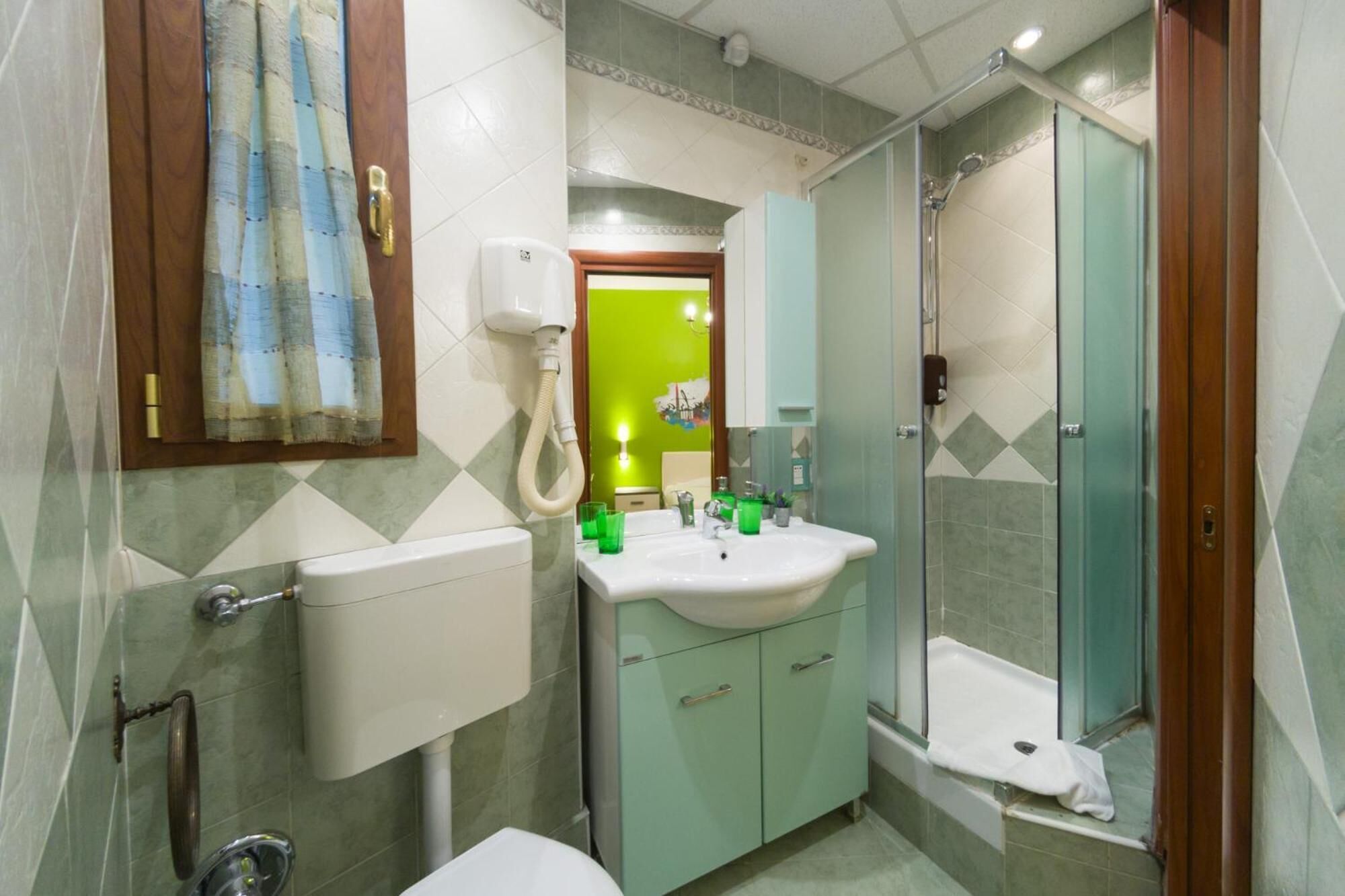 A bathroom with a toilet, sink, and shower.