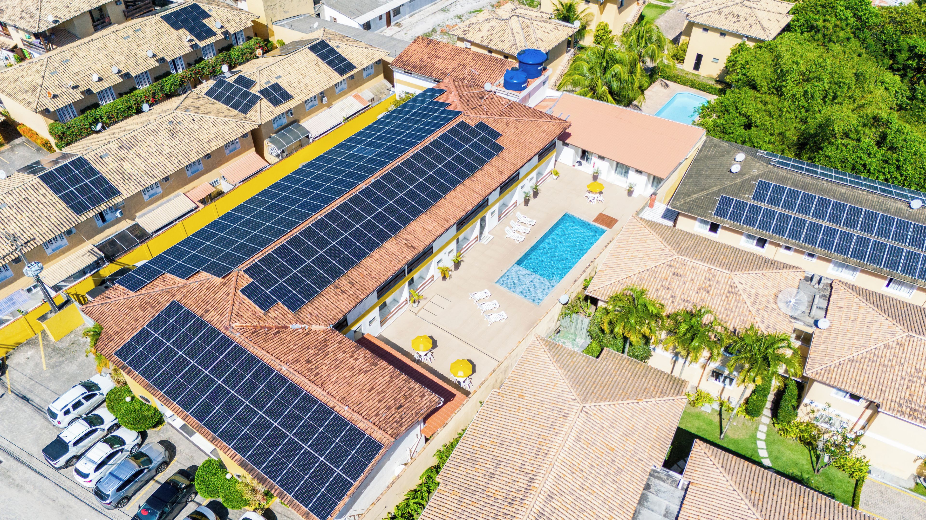 Un quartier résidentiel composé de plusieurs maisons, chacune étant équipée de panneaux solaires sur son toit.
