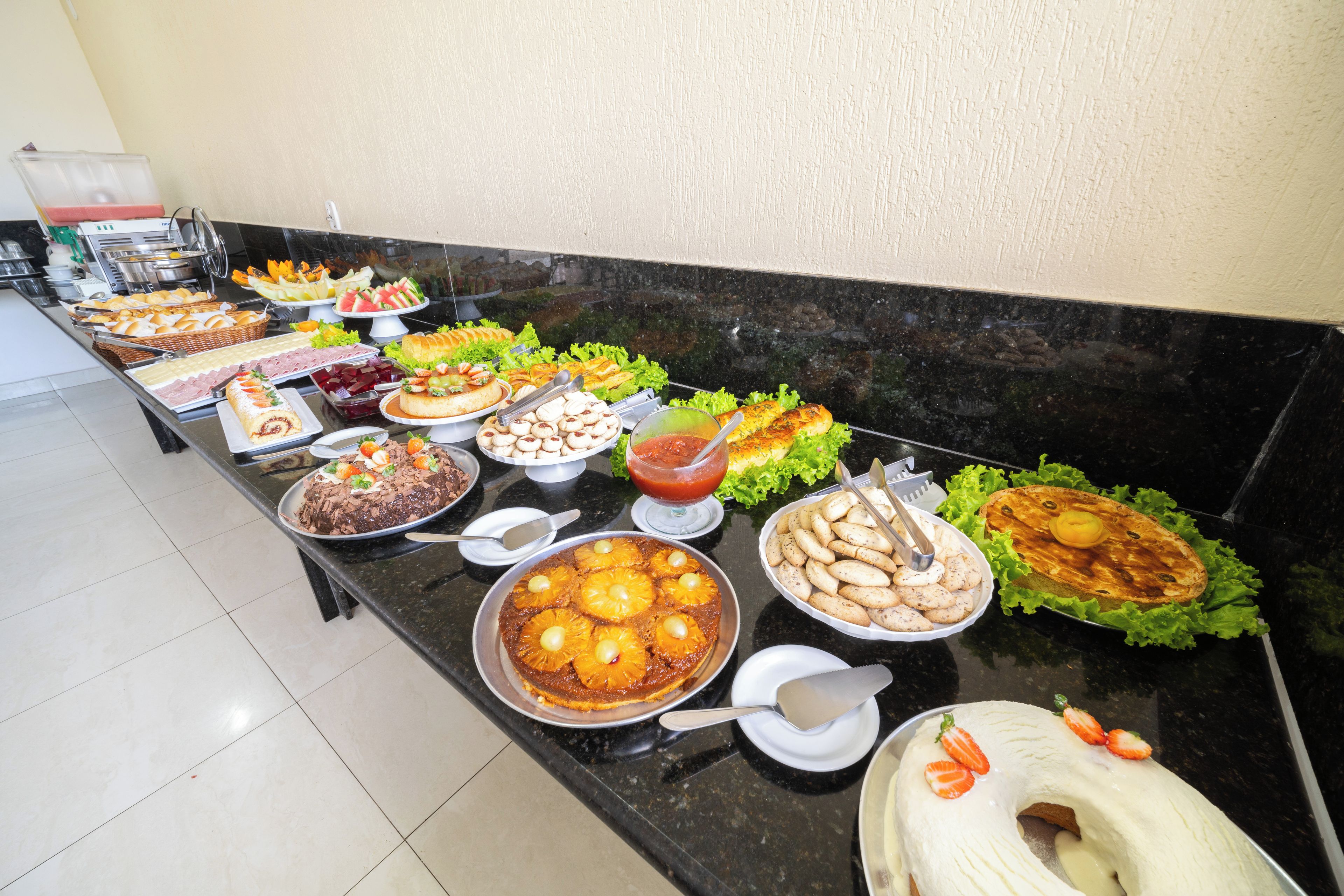 A buffet with a variety of food items including bread, salads, and desserts.