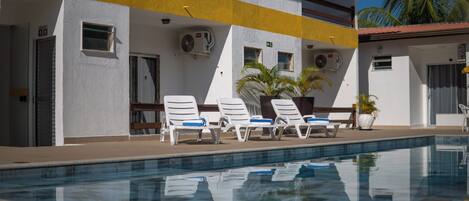 Alberca al aire libre y camastros