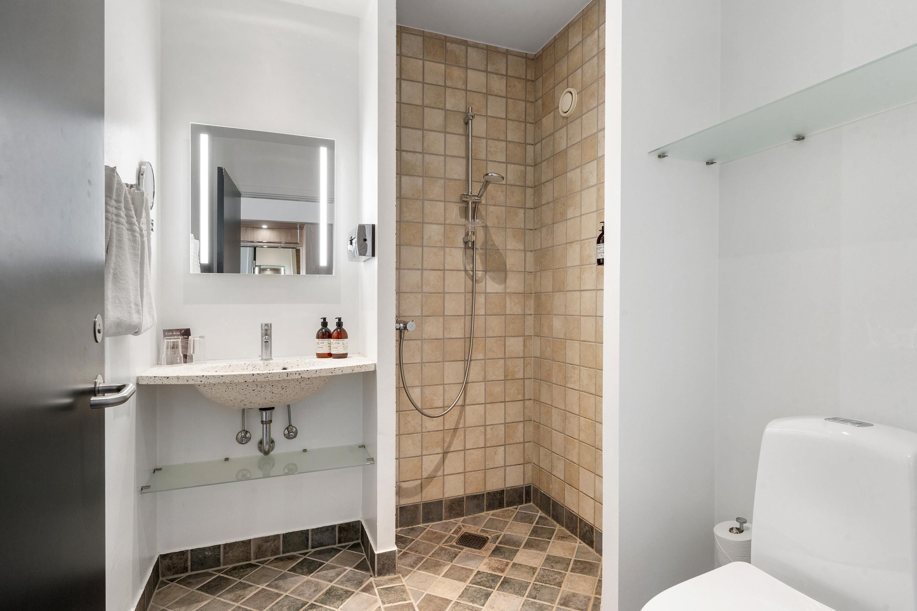 A bathroom with a shower, sink, and toilet.