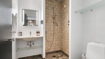 A bathroom with a shower, sink, and toilet.