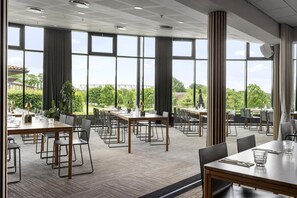 A spacious dining area with multiple tables and chairs, large windows, and a view of greenery outside. - Trinity Hotel og Konference, BW Signature Collection (Fredericia)