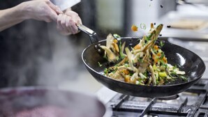 A chef tossing food in a wok. - Trinity Hotel og Konference, BW Signature Collection (Fredericia)