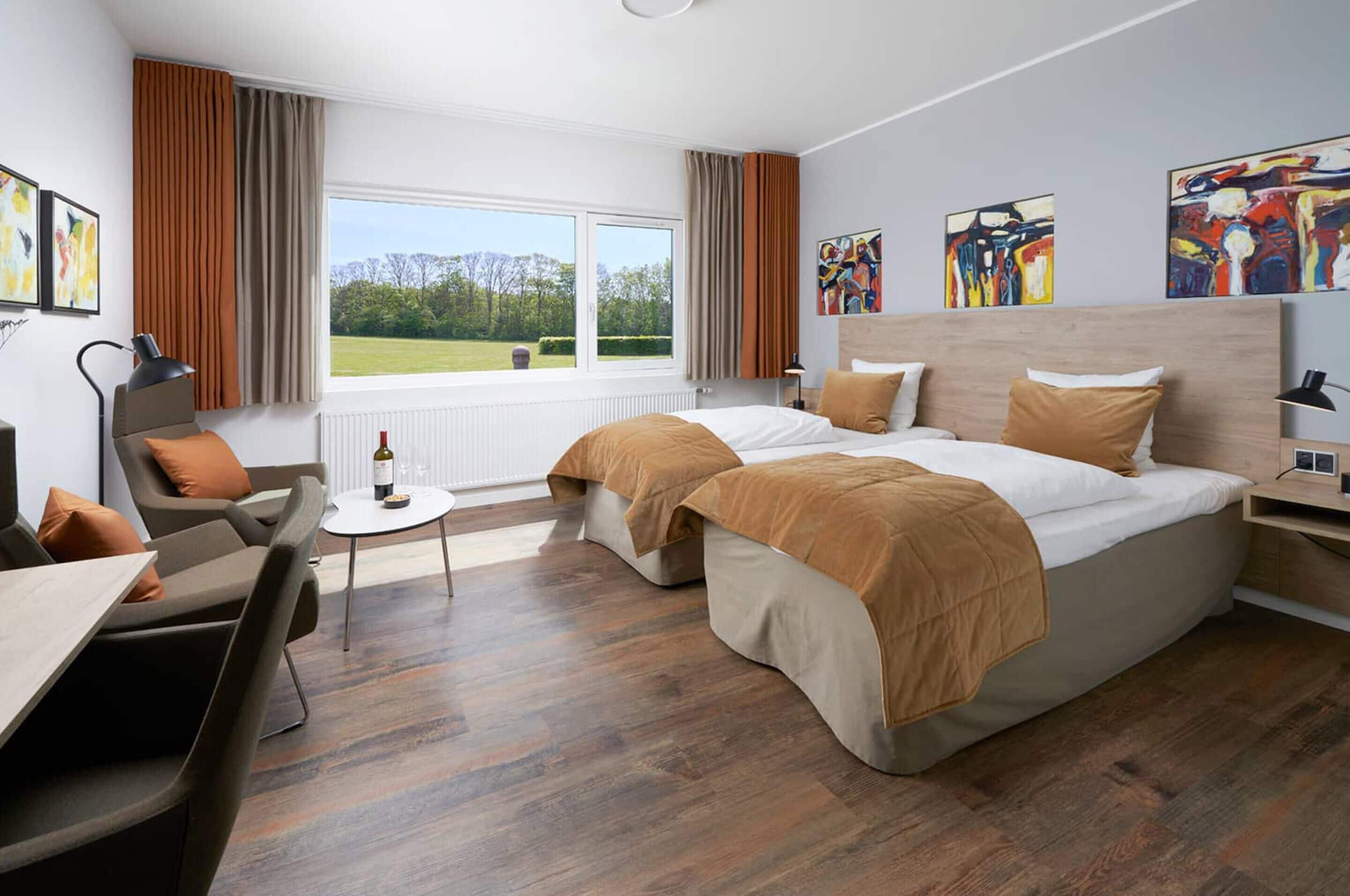Een hotelkamer met een groot bed, een bureau, een stoel en uitzicht op de omgeving.