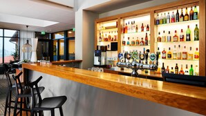 A bar area with a wooden counter, multiple seating options, and a well-stocked liquor shelf. - Trinity Hotel og Konference, BW Signature Collection (Fredericia)