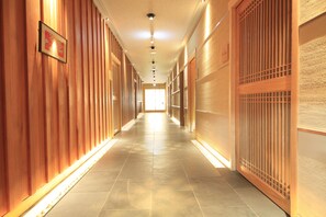 A long hallway with wooden paneling on the walls and a tiled floor.