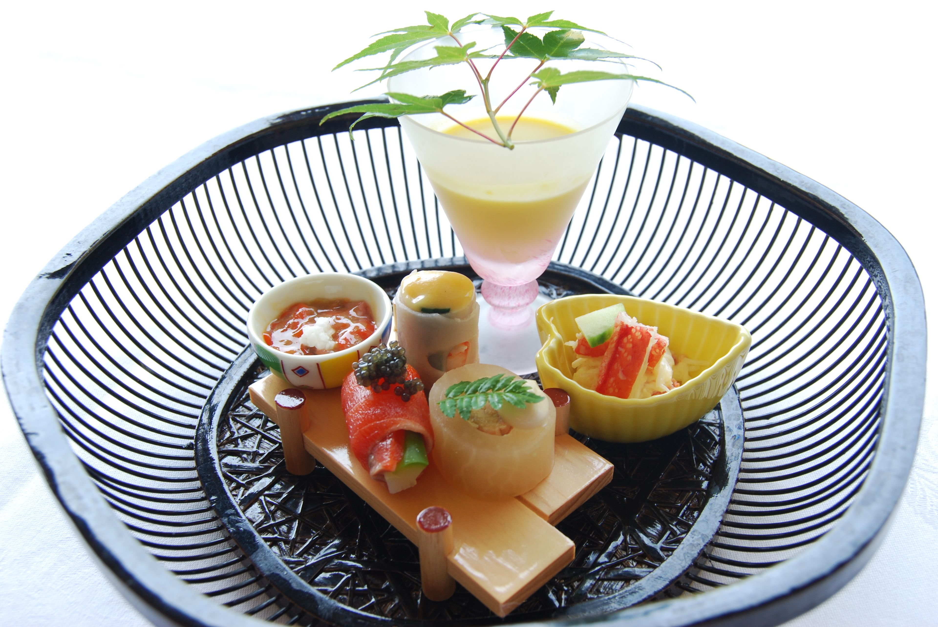 A black and white striped tray with various food items and a drink.