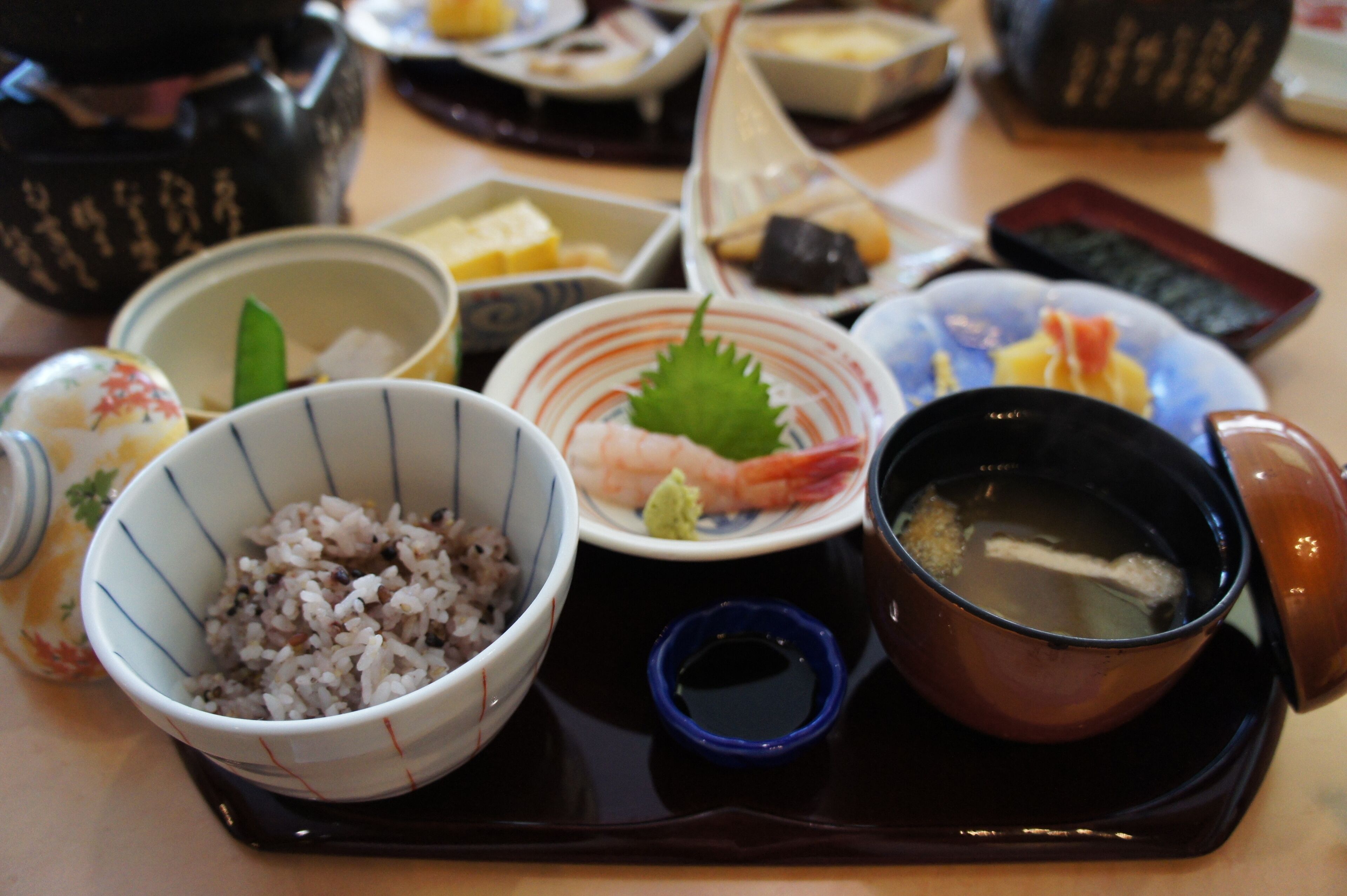 A tray with various dishes including rice, shrimp, and soup.