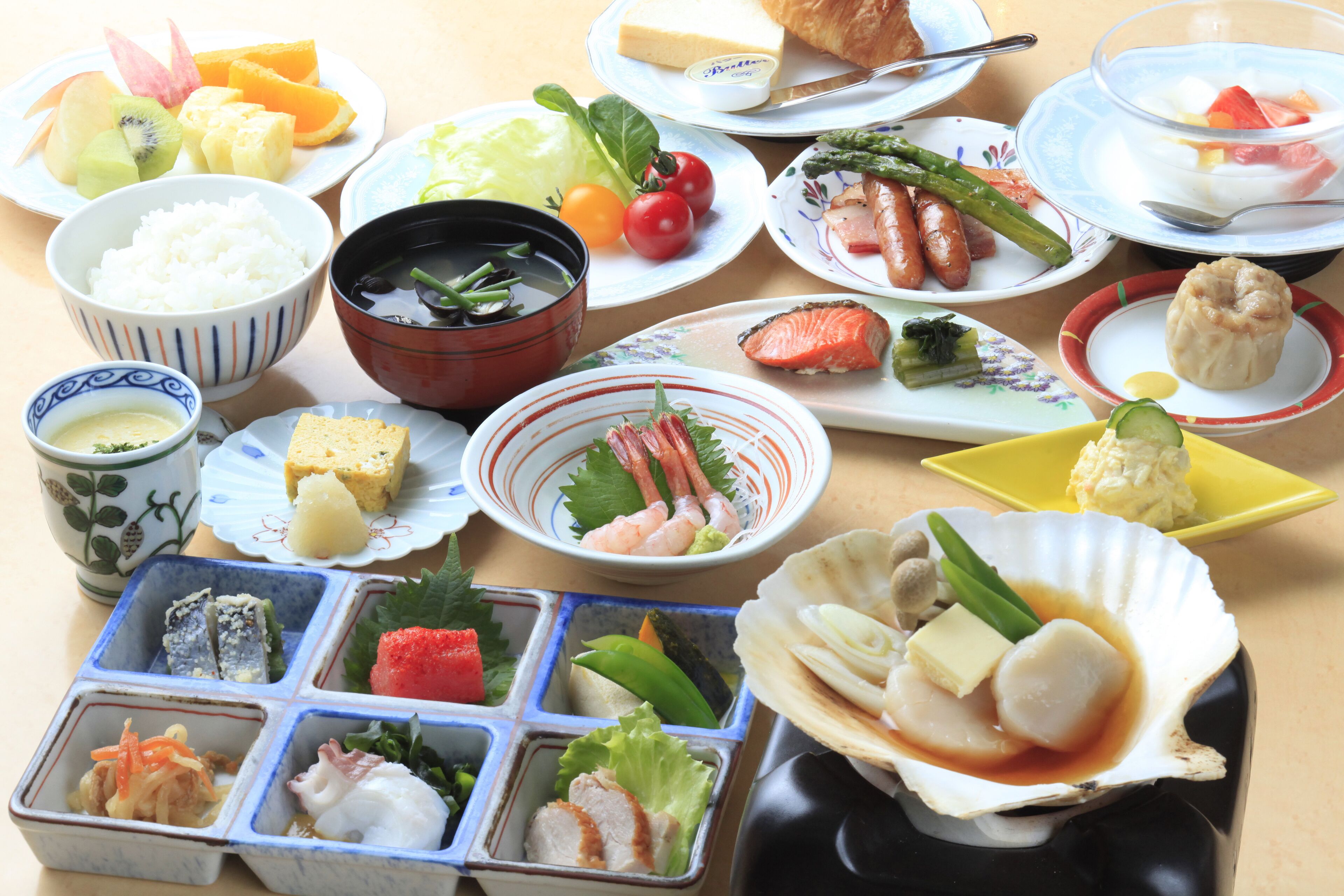 A variety of dishes including sushi, sashimi, and a bowl of soup.