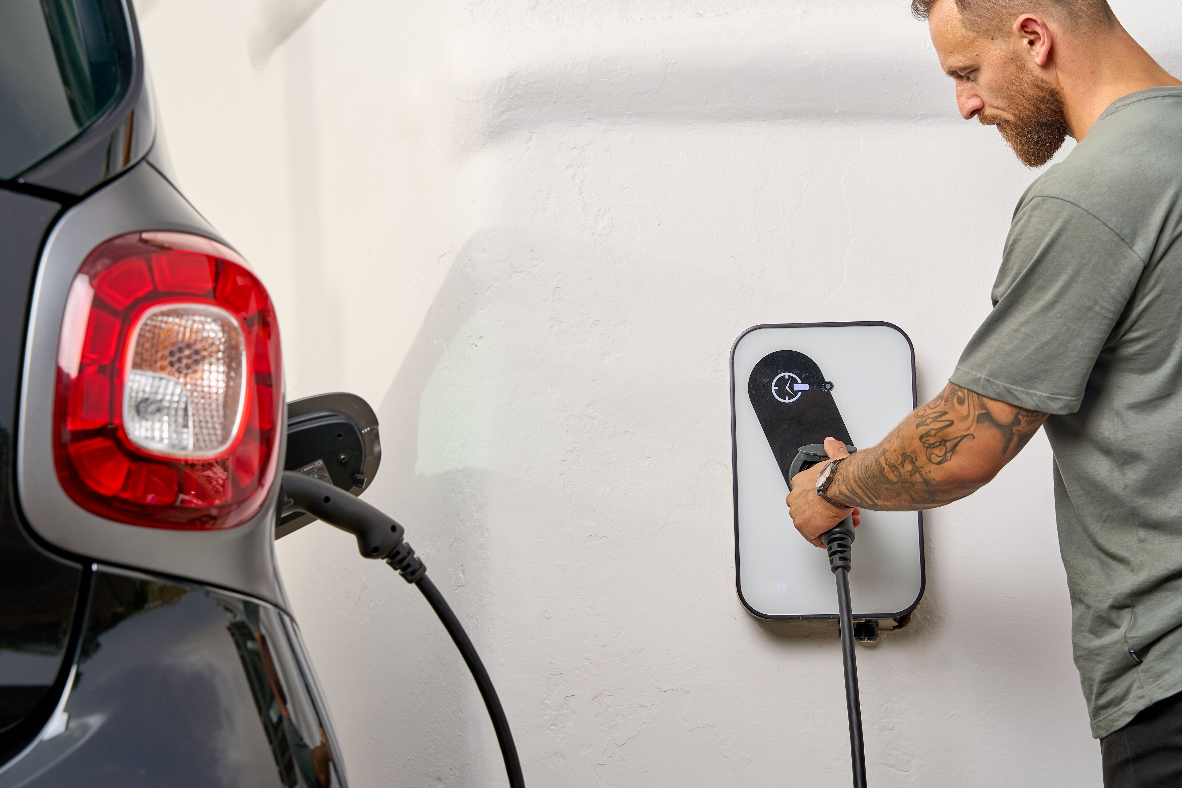 A person charging a car at a public charging station.