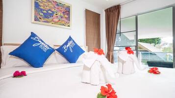 A hotel room with a bed, pillows, a painting, and a view of the outdoors.