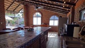 Una cocina con salpicadero de azulejos, un lavamanos y una ventana.