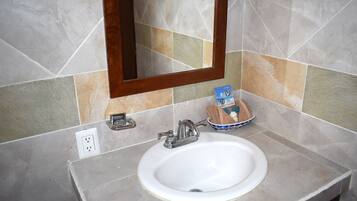 Une salle de bain avec un lavabo blanc, un miroir et un porte-serviettes.