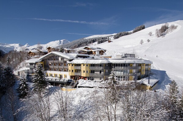 Surrounded by snow-covered mountains and trees, this hotel offers stunning views and easy access to ski slopes.