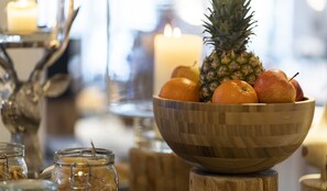 Un cuenco de madera con frutas sobre un pedestal de madera.