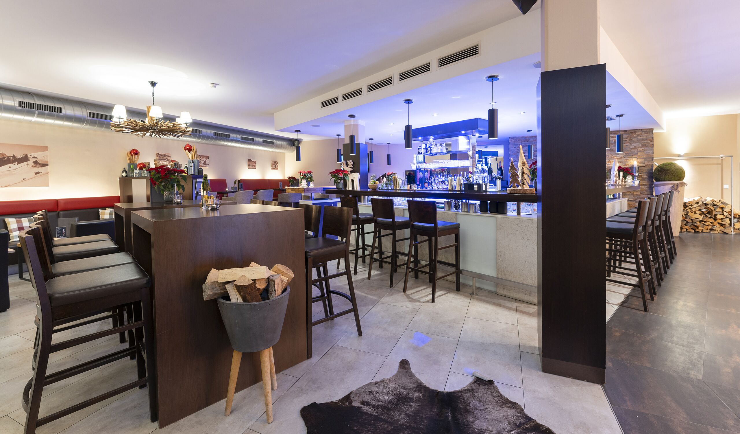 Een moderne bar met een toonbank, zitplaatsen en een open haard.