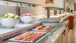 Um buffet com diversas frutas e carnes.