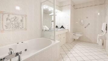 A modern bathroom with a freestanding bathtub, a sink with a mirror, and a toilet.