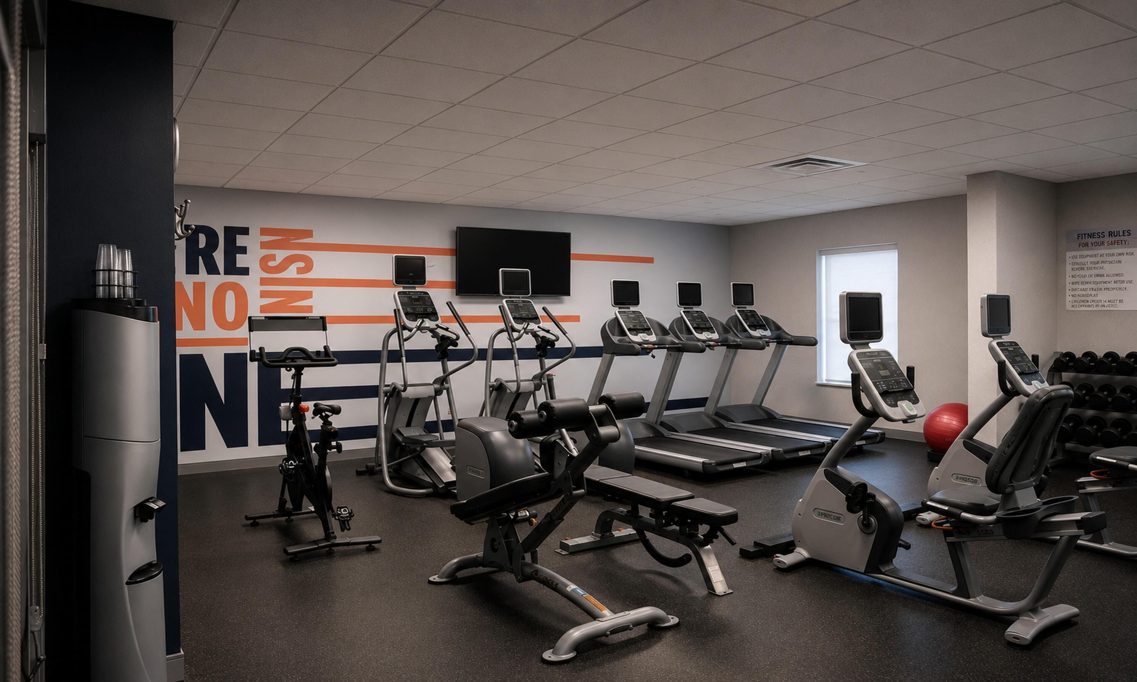 A fitness center with treadmills, elliptical machines, and free weights.