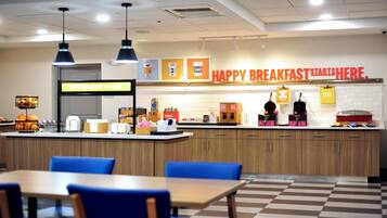 Een ontbijtruimte met een aanrecht, zitplaatsen en een bord waarop staat 'HAPPY BREAKFAST START HERE'.