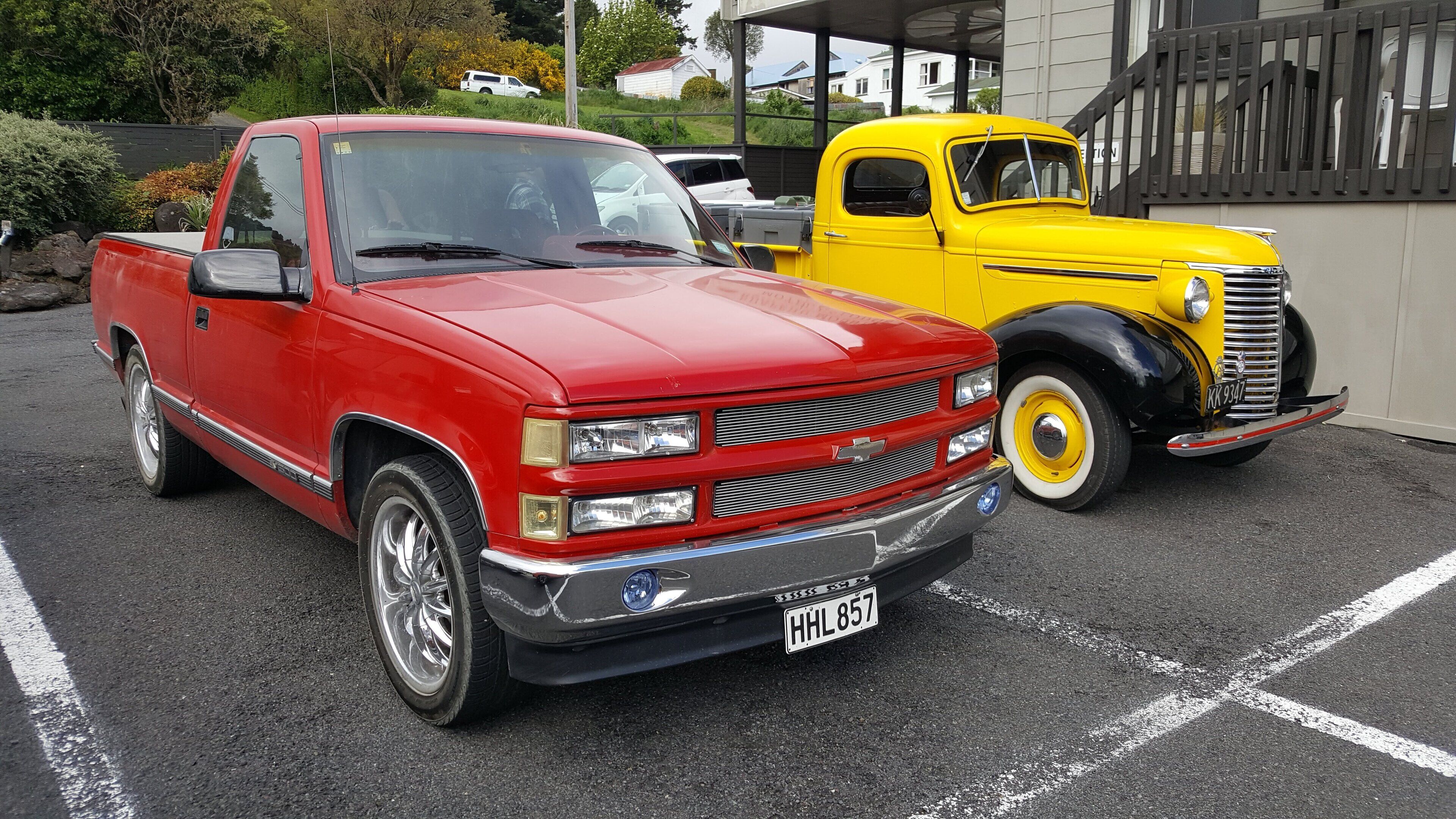 Una camioneta roja y una camioneta amarilla estacionadas en un estacionamiento.