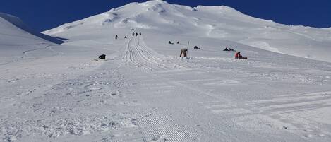 A snowy mountain slope with skiers and snowboarders.