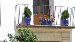A building with a sign reading "APARTAMENTOS COLEGIATAS" and a balcony with potted plants. - La Colegiata de Ronda (Ronda)