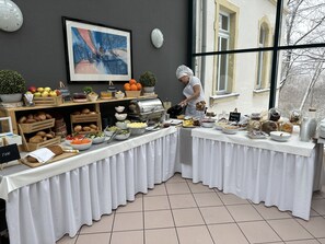 Un buffet proposant une grande variété de plats, avec un chef qui prépare les aliments.